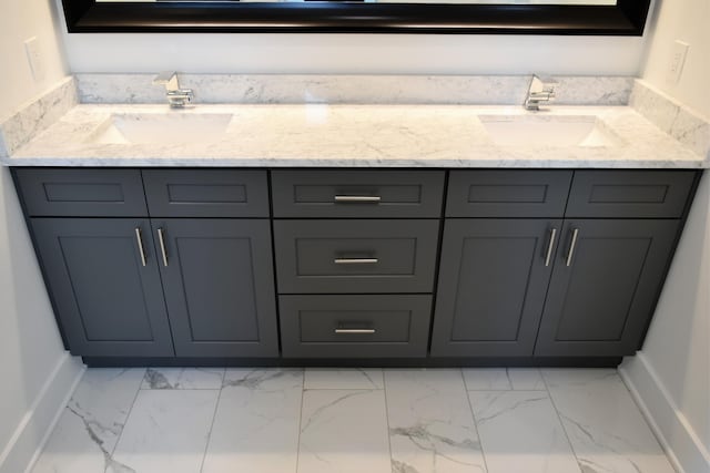 bathroom featuring marble finish floor, a sink, and baseboards