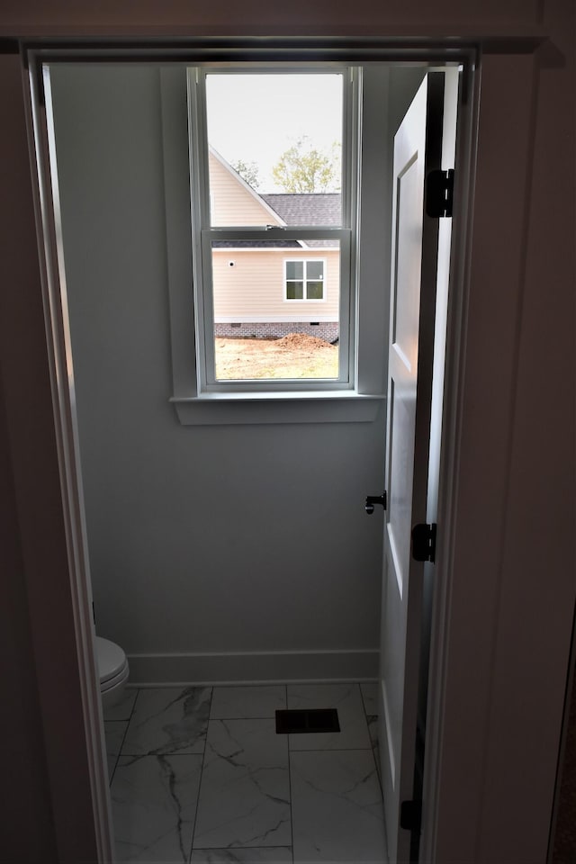 bathroom featuring marble finish floor, toilet, and baseboards