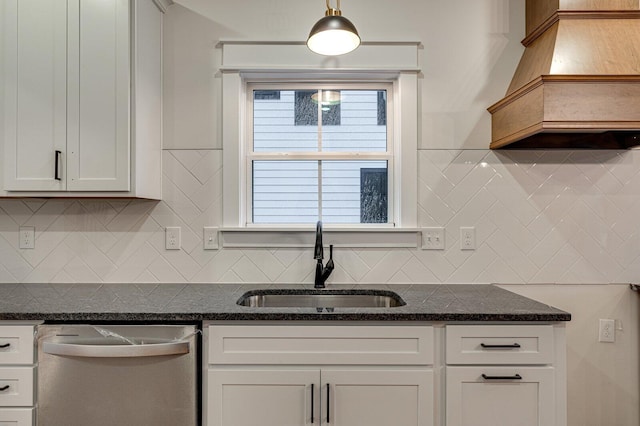 kitchen featuring white cabinetry, sink, tasteful backsplash, stainless steel dishwasher, and dark stone countertops