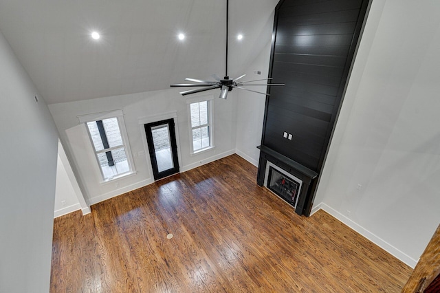 unfurnished living room with ceiling fan, dark hardwood / wood-style flooring, and vaulted ceiling