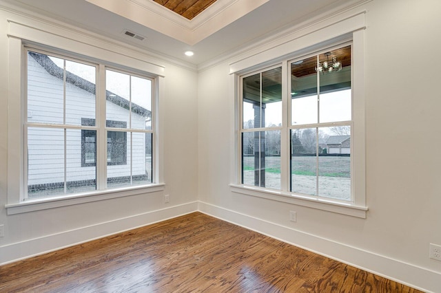 unfurnished room featuring crown molding, a healthy amount of sunlight, and wood-type flooring