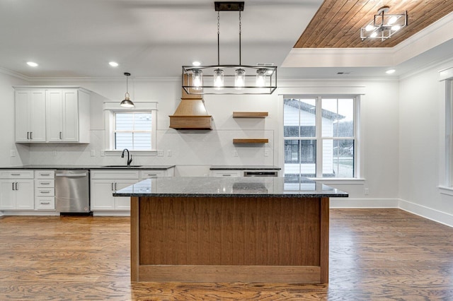 kitchen featuring backsplash, white cabinets, dark stone counters, and decorative light fixtures