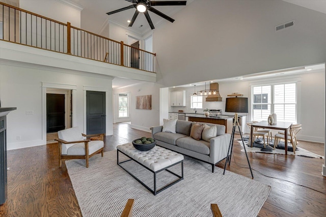 111 Arthur Ln NW, Cleveland, TN 37312 - living room with a towering ceiling, a ceiling fan, baseboards, crown molding, and dark wood-type flooring