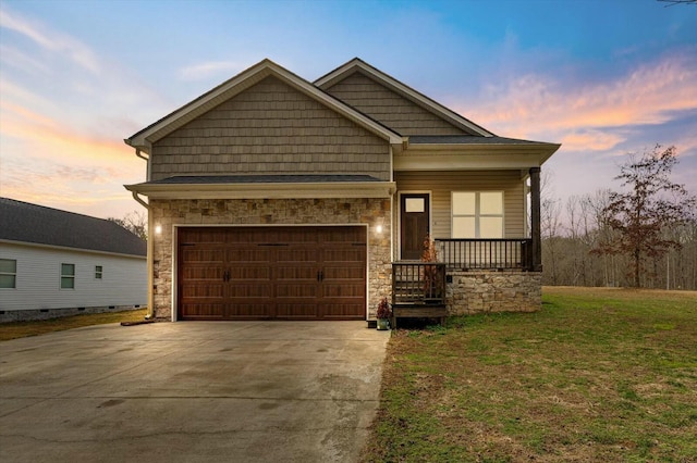 craftsman-style house with a garage, covered porch, and a lawn