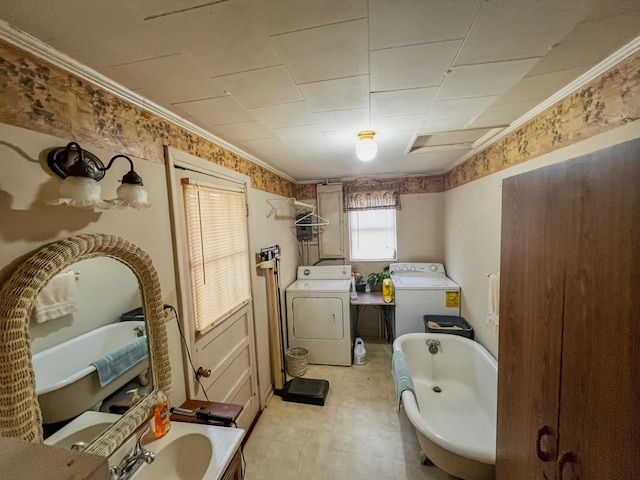 bathroom featuring washer and dryer, a bathtub, sink, and crown molding