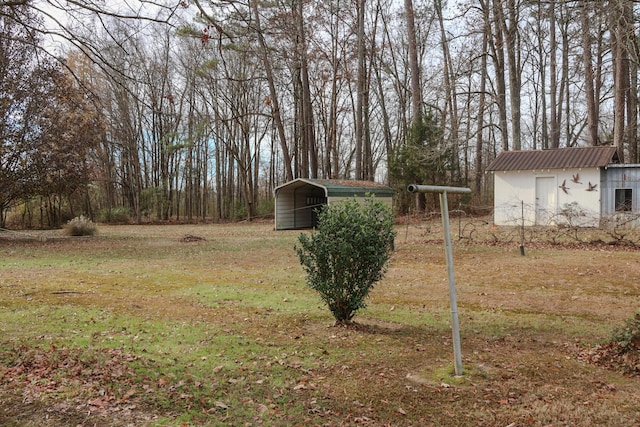 view of yard featuring a storage unit and a carport