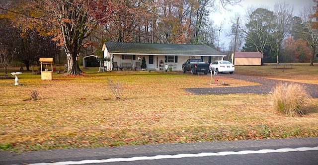 ranch-style house featuring a carport, covered porch, and a front yard