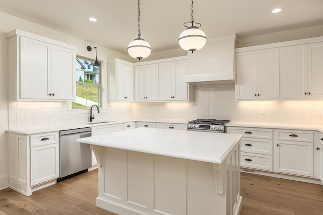 kitchen with custom range hood, a center island, stainless steel appliances, and white cabinetry