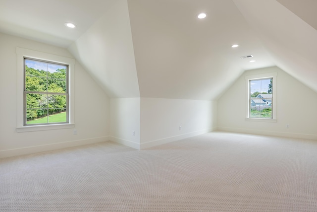 bonus room featuring light carpet, plenty of natural light, and lofted ceiling