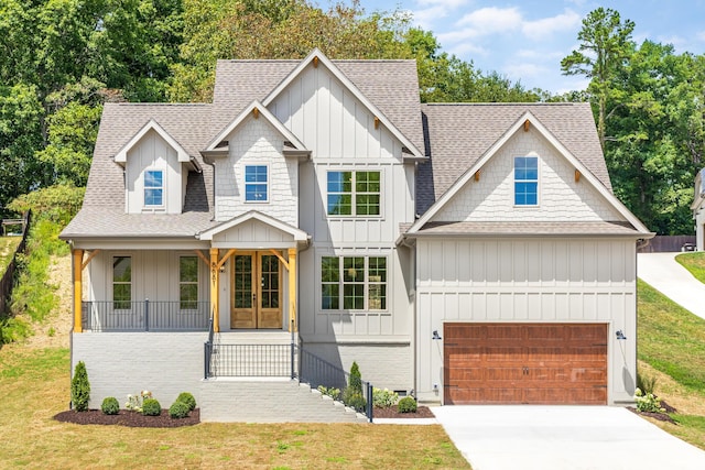 view of front of home featuring covered porch, french doors, a garage, and a front yard