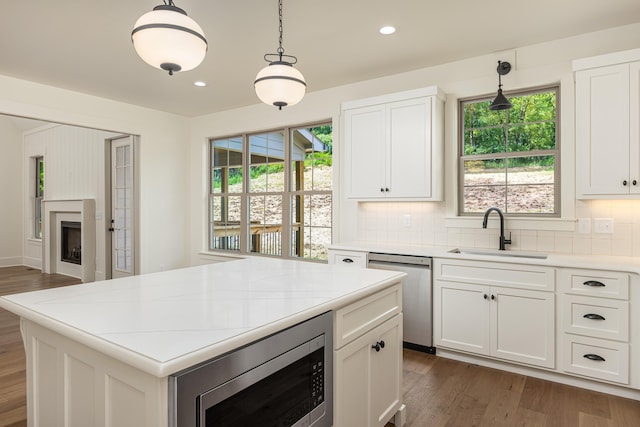 kitchen featuring sink, hanging light fixtures, dark hardwood / wood-style flooring, white cabinets, and appliances with stainless steel finishes