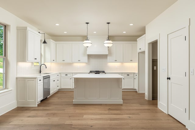 kitchen with a center island, light hardwood / wood-style floors, stainless steel dishwasher, and a healthy amount of sunlight