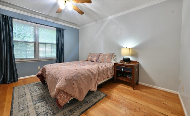 bedroom featuring a ceiling fan, baseboards, ornamental molding, and wood finished floors
