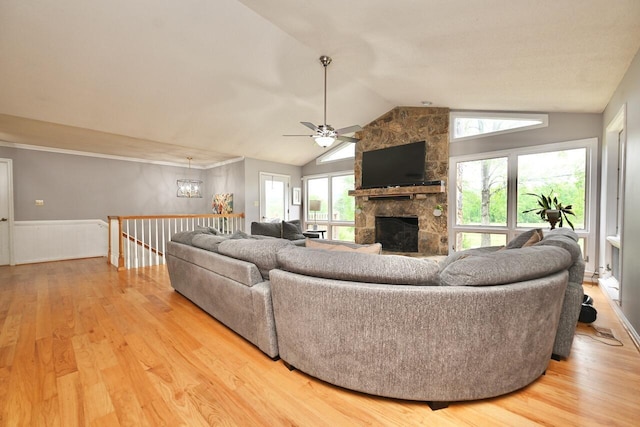 living area with light wood-style flooring, lofted ceiling, and a fireplace