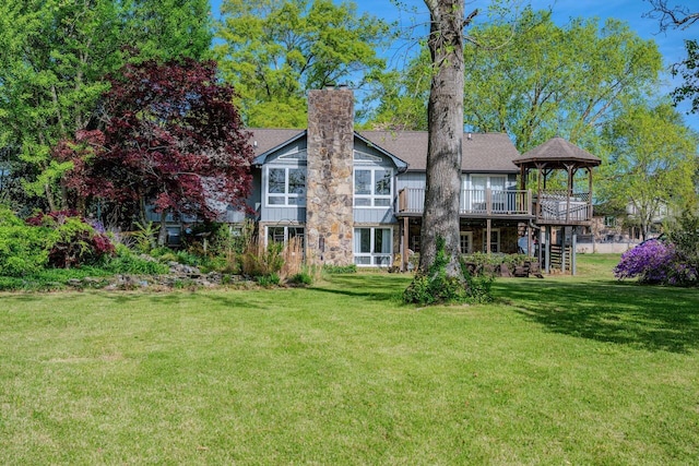 rear view of property with a lawn, stairs, a chimney, and a deck