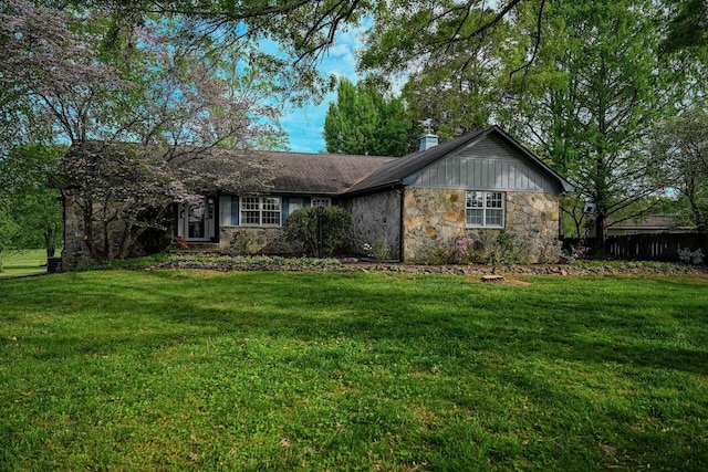 ranch-style home featuring a front yard and stone siding