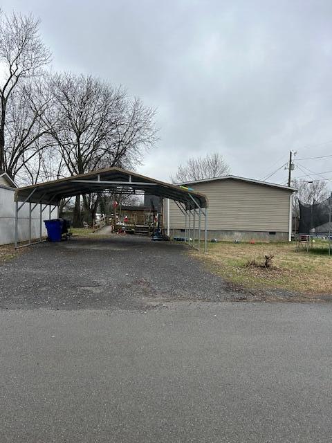 view of car parking featuring a trampoline and a carport