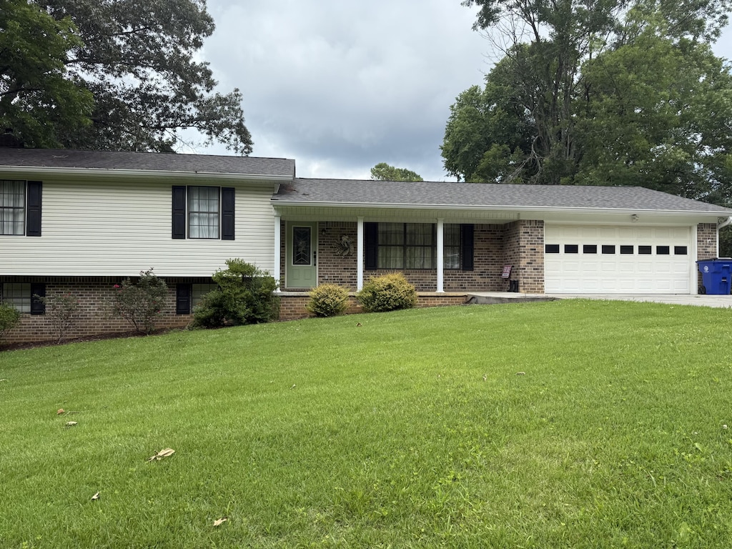 2275 Tenneesee Nursery Rd, Cleveland, TN 37311 - split level home featuring an attached garage, a front yard, brick siding, driveway, and covered porch