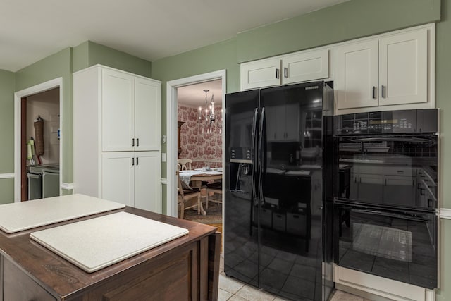 kitchen with a chandelier, light tile patterned floors, white cabinetry, and black appliances