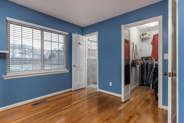 unfurnished bedroom with wood-type flooring and a closet