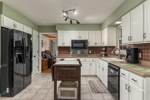 kitchen featuring decorative backsplash, sink, white cabinets, and black appliances