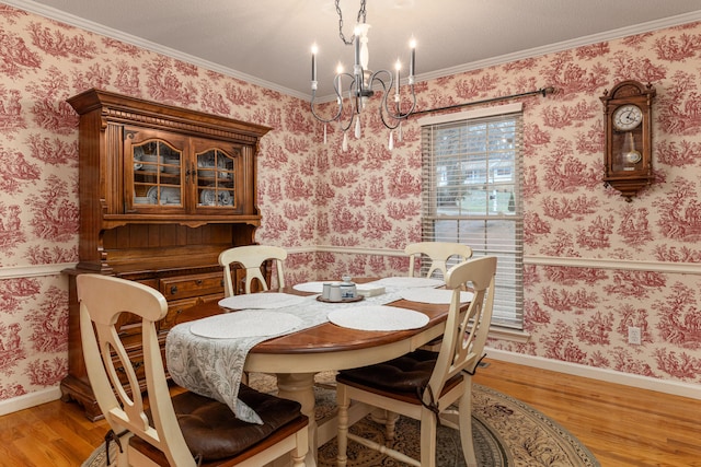 dining room with a chandelier, light hardwood / wood-style floors, and ornamental molding