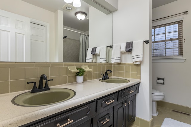 bathroom featuring tile patterned flooring, vanity, toilet, and backsplash