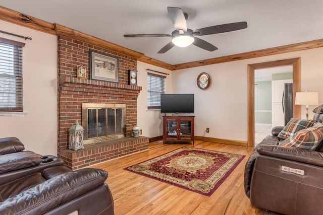 living room with hardwood / wood-style flooring, ceiling fan, a fireplace, and a wealth of natural light