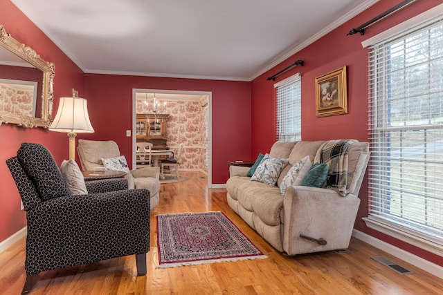 living room featuring hardwood / wood-style flooring, a wealth of natural light, and ornamental molding