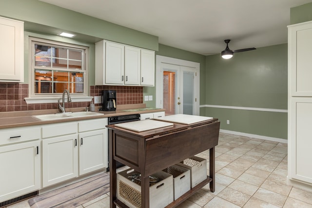 kitchen featuring white cabinetry, sink, and tasteful backsplash