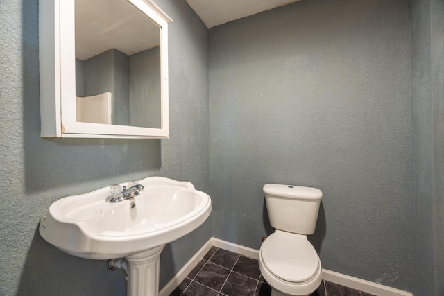 bathroom with tile patterned flooring, toilet, and sink