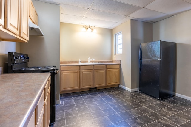 kitchen featuring a paneled ceiling, sink, black appliances, and a notable chandelier