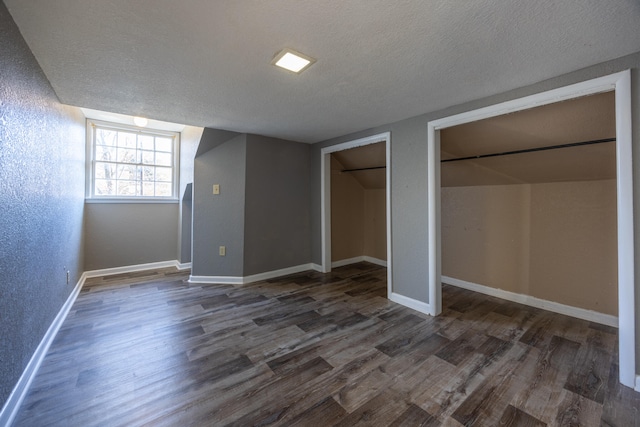 unfurnished bedroom featuring dark hardwood / wood-style flooring and a textured ceiling