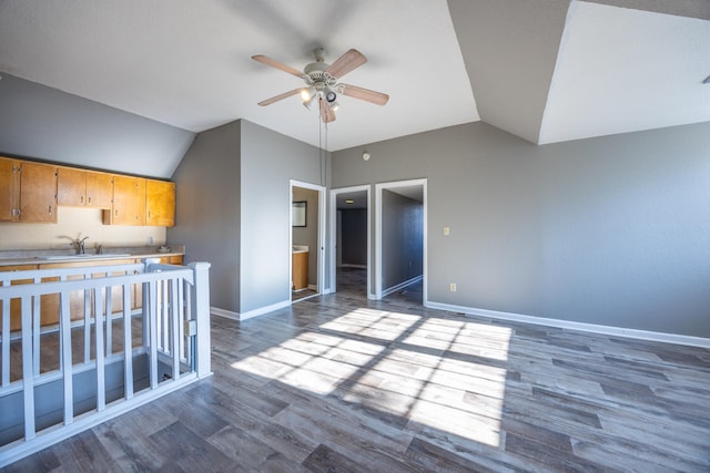 interior space with ceiling fan, sink, wood-type flooring, and lofted ceiling