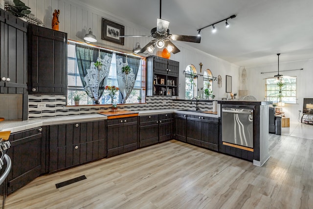 kitchen featuring pendant lighting, dishwasher, light hardwood / wood-style floors, and ornamental molding