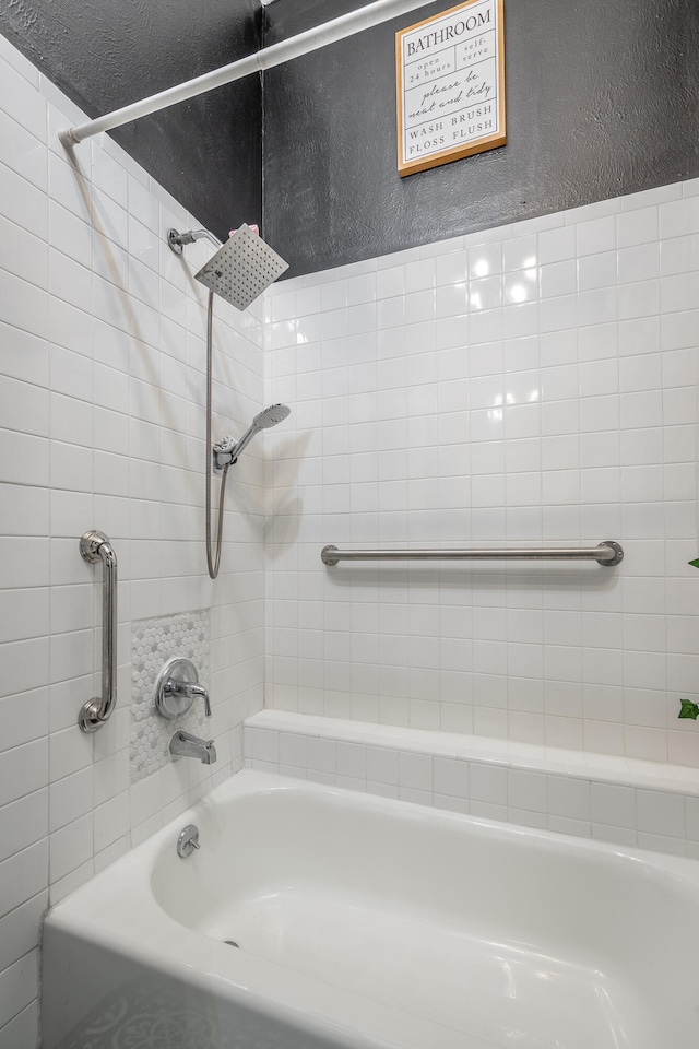 bathroom with a textured ceiling and tiled shower / bath