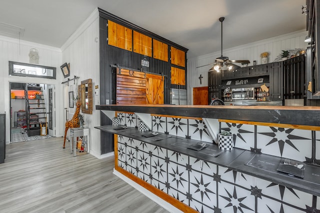 bar with wooden walls, light hardwood / wood-style floors, ceiling fan, and crown molding