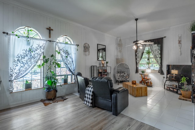 living room featuring ceiling fan, a healthy amount of sunlight, light hardwood / wood-style floors, and crown molding