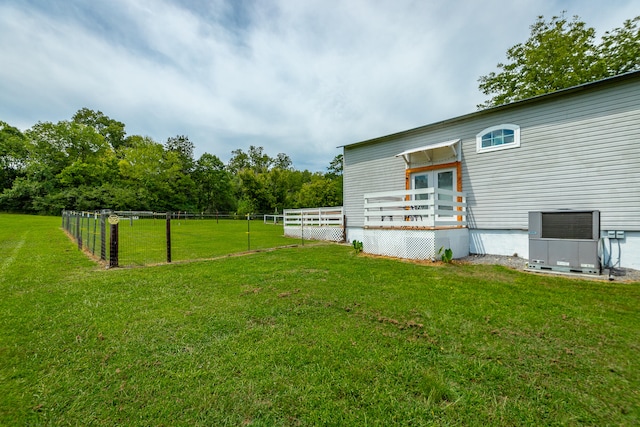 view of yard with central AC and a wooden deck