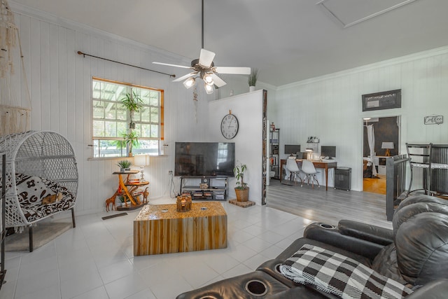 living room featuring crown molding, ceiling fan, and wood walls