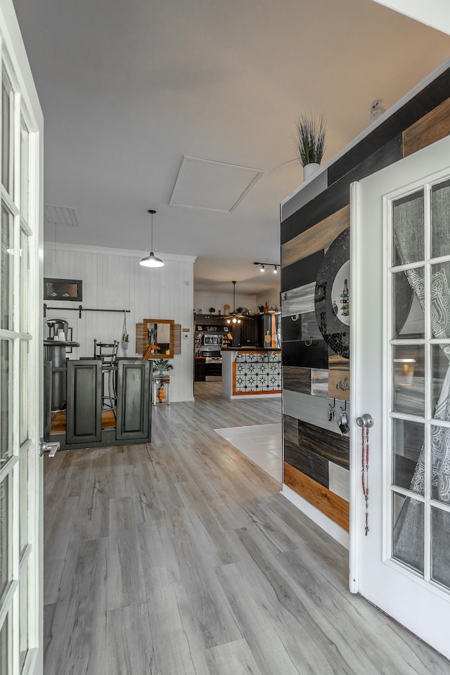 corridor with wood walls and light hardwood / wood-style flooring