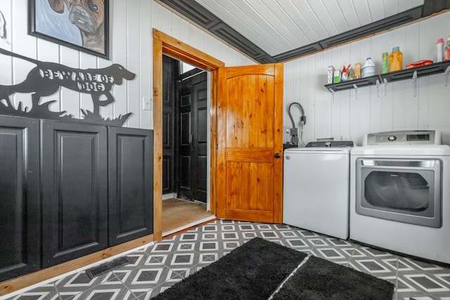 washroom with wood walls, separate washer and dryer, and crown molding