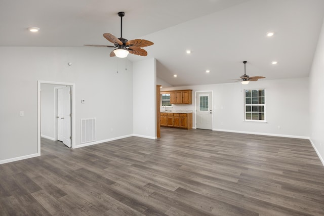 unfurnished living room with ceiling fan, high vaulted ceiling, and dark wood-type flooring