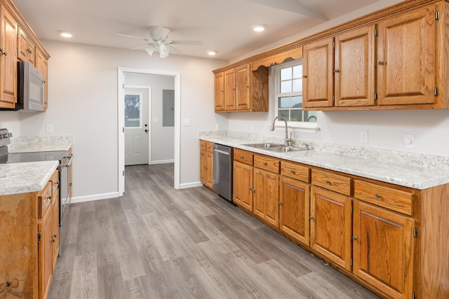 kitchen featuring ceiling fan, sink, stainless steel appliances, electric panel, and hardwood / wood-style flooring