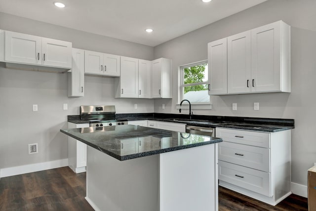 523 13th St SE, Cleveland, TN 37311 - kitchen with stainless steel appliances, white cabinets, dark wood finished floors, baseboards, and dark stone counters