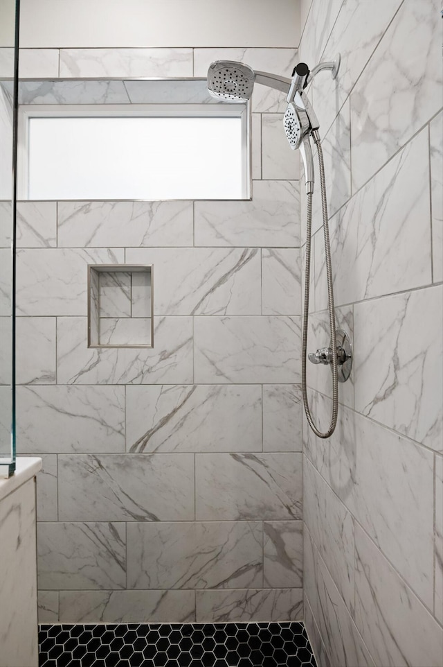 full bath with plenty of natural light and a tile shower