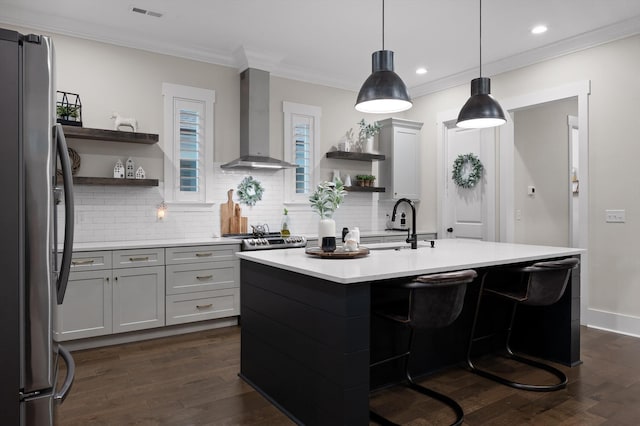 kitchen with open shelves, light countertops, wall chimney exhaust hood, freestanding refrigerator, and decorative backsplash