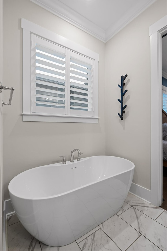 full bathroom with baseboards, ornamental molding, marble finish floor, and a soaking tub