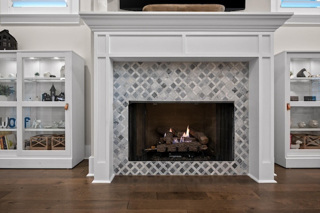 details with baseboards, wood finished floors, and a fireplace