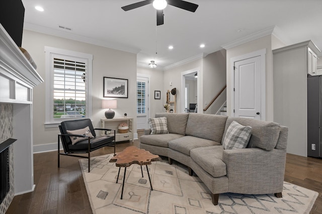 living area with visible vents, crown molding, wood finished floors, and ceiling fan